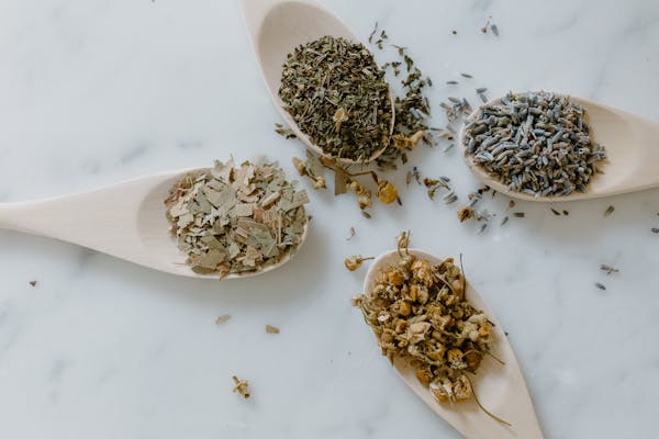 Dried herbs on spoons